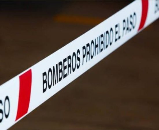 Cinta de balizamiento para delimitar el paso blanca y roja con texto en negro con el texto "prohibido el paso"